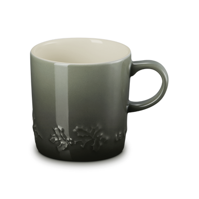 Green ceramic mug with floral design on a white background
