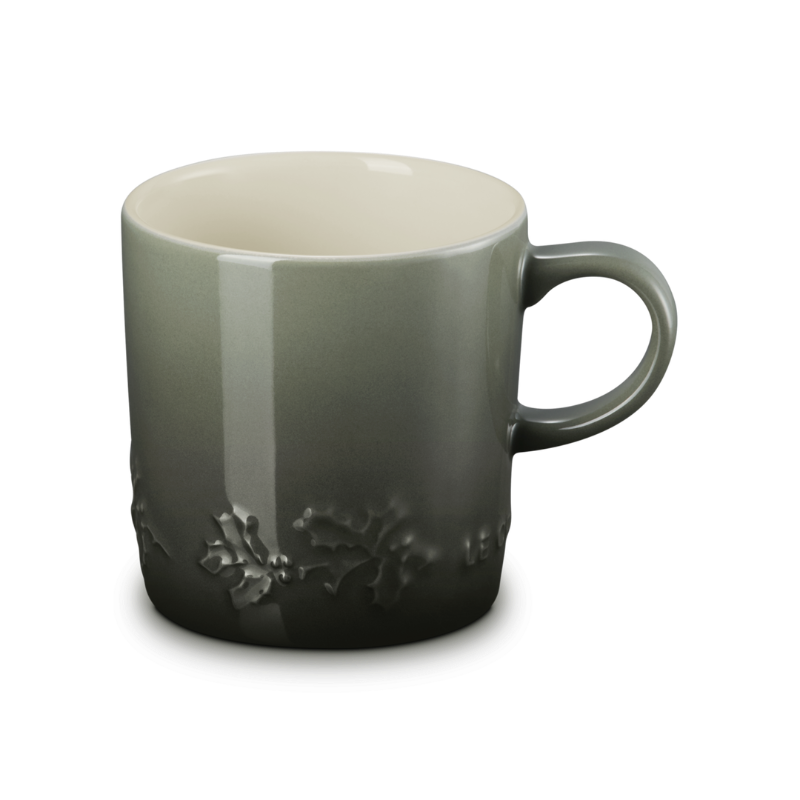 Green ceramic mug with floral design on a white background