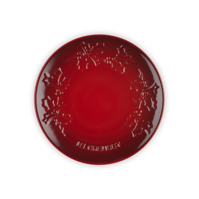 Red decorative plate with intricate patterns on a white background