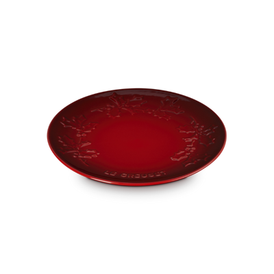 Red ceramic plate with intricate design on a white background