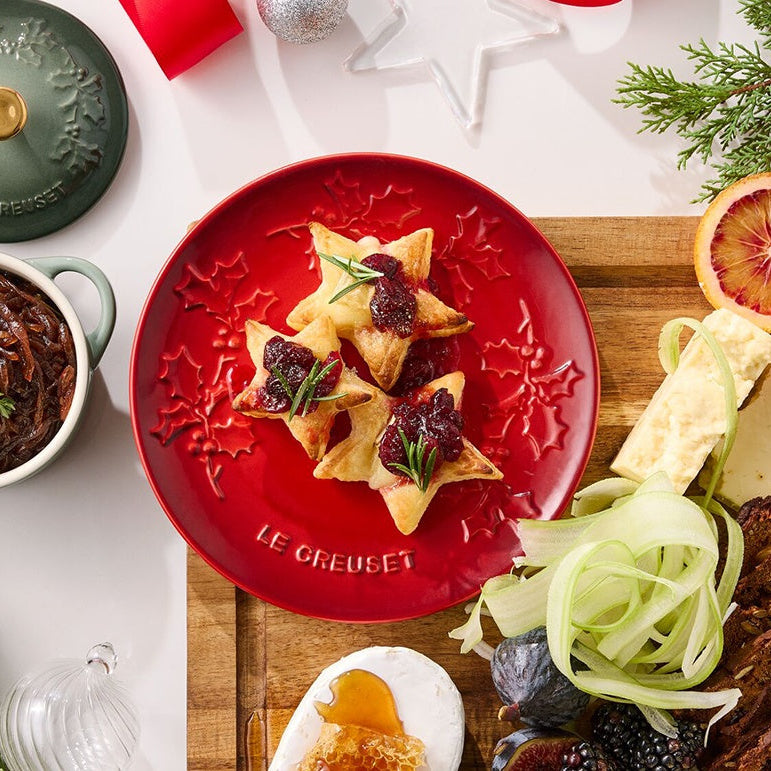 Assorted food items on a table with a red plate featuring star-shaped appetizers.