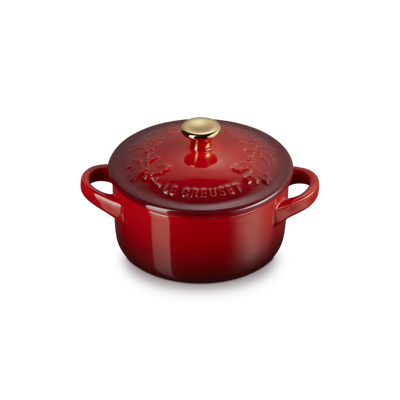 Red enameled cast iron cookware pot with lid on a white background