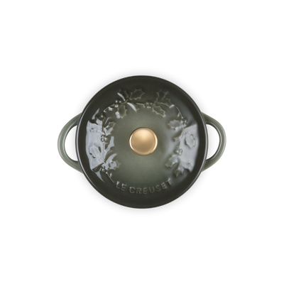 Green cast iron cookware with a gold knob on a white background