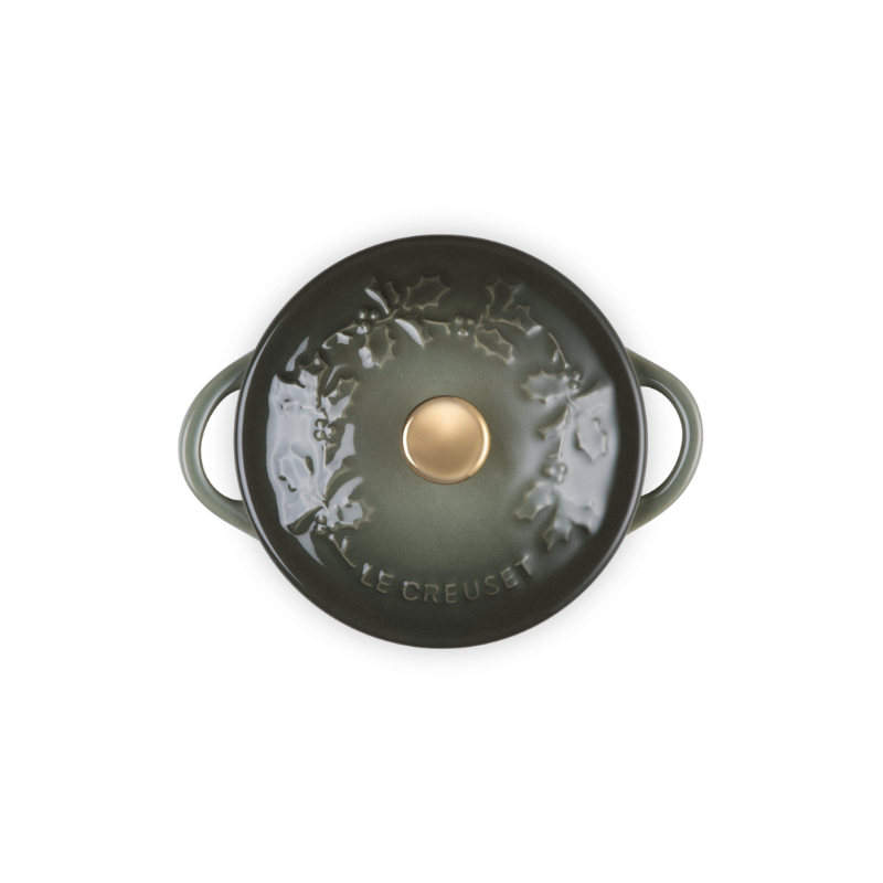 Green cast iron cookware with a gold knob on a white background