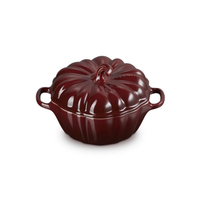 Red ceramic cocotte with a lid on a white background