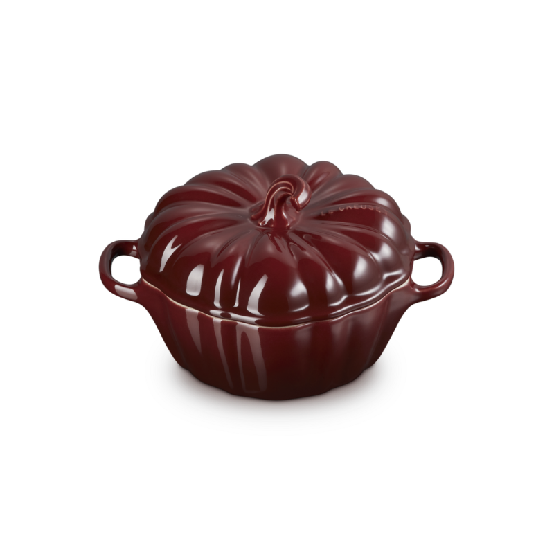Red ceramic cocotte with a lid on a white background
