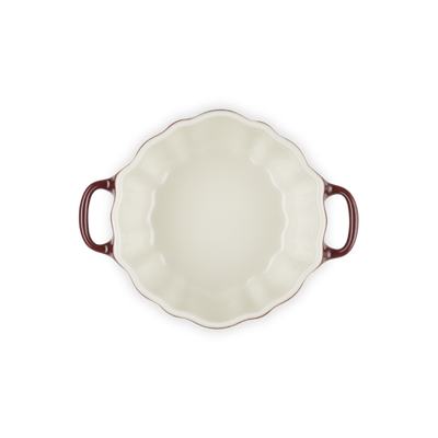White ceramic pie dish with red-brown handles on a white background