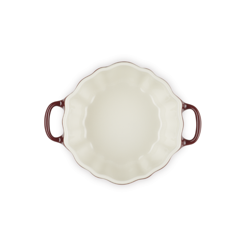 White ceramic pie dish with red-brown handles on a white background