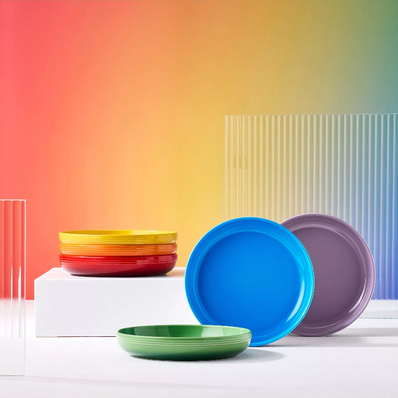 Set of colorful plates on a white surface with a gradient background