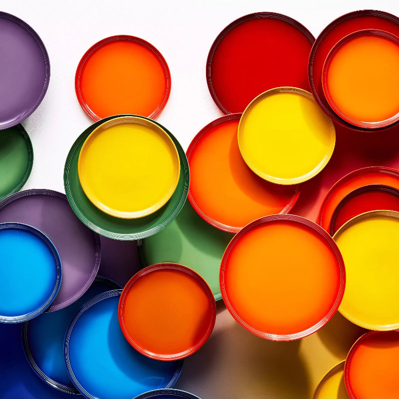 Assorted colorful paint cans arranged in a circular pattern on a white background