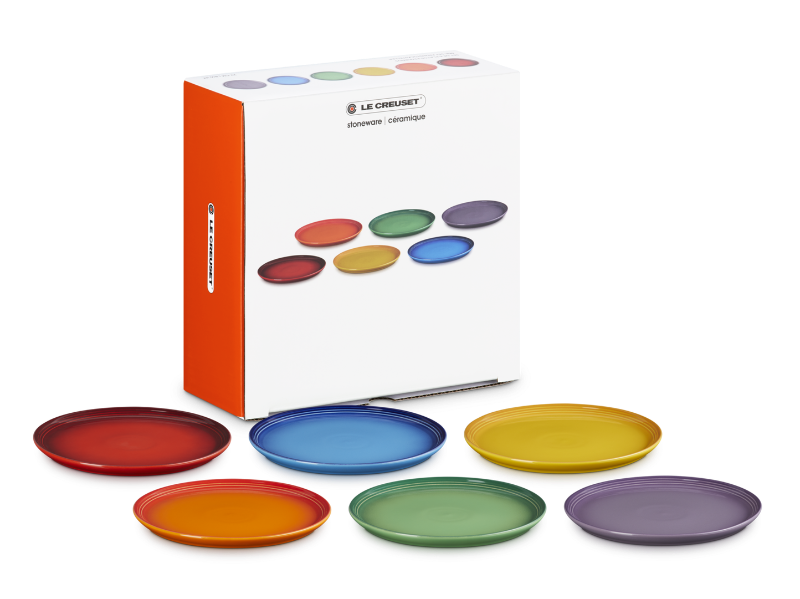 Set of colorful plates with a Le Creuset box on a white background