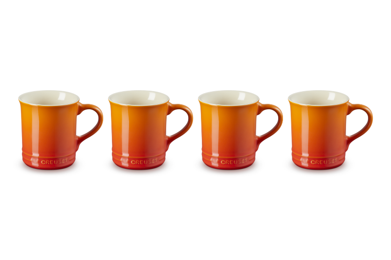 Four orange mugs with white interiors on a white background