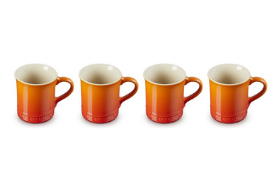 Four orange mugs with white interiors on a white background