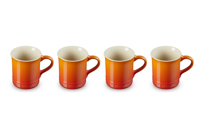 Four orange mugs with white interiors on a white background