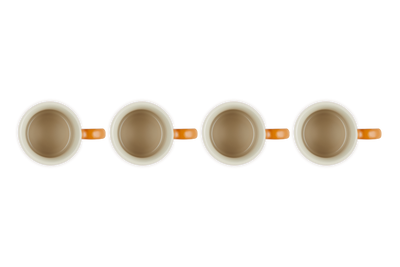 Four white mugs with orange handles on a white background