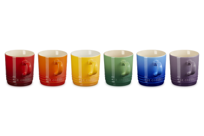 Set of six colorful mugs arranged in a row on a white background