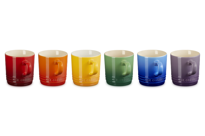 Set of six colorful mugs arranged in a row on a white background
