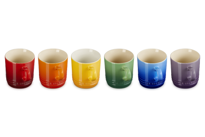 Set of six colorful mugs arranged in a row on a white background