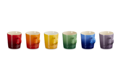 Set of seven colorful mugs arranged in a row on a white background