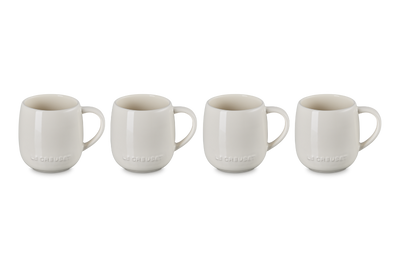 Set of four white ceramic mugs on a white background
