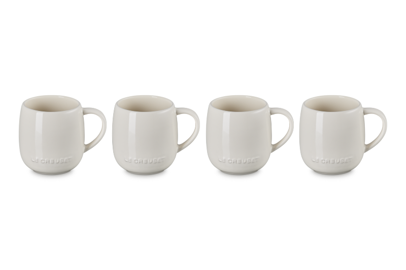 Set of four white ceramic mugs on a white background