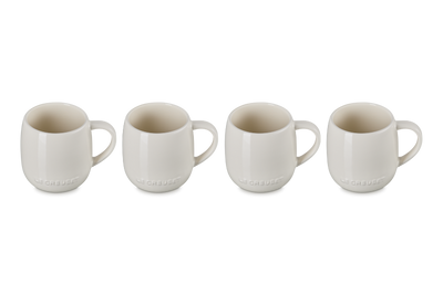 Set of four white ceramic mugs on a white background