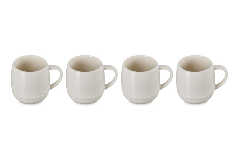 Set of four white ceramic mugs on a white background