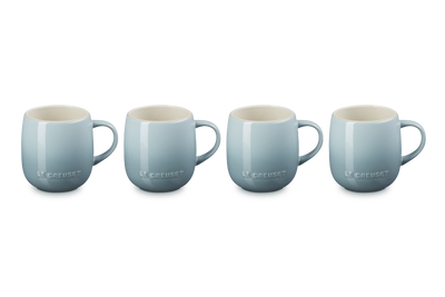 Four light blue mugs with white interiors on a white background