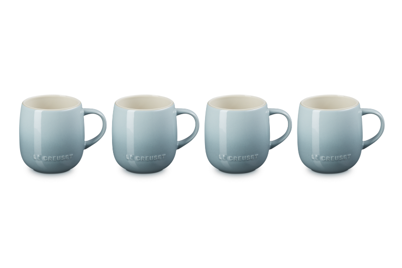 Four light blue mugs with white interiors on a white background