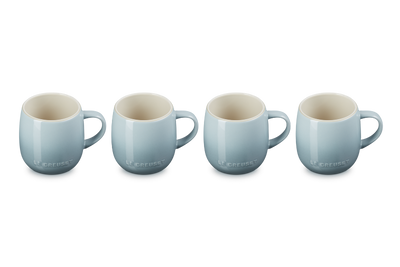 Set of four light blue mugs with white interiors on a white background