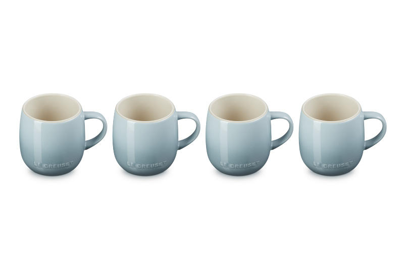 Set of four light blue mugs with white interiors on a white background