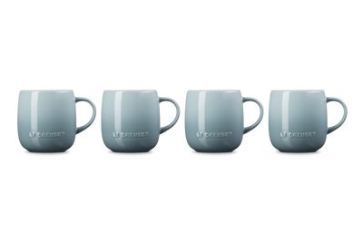 Four light blue mugs with 'Le Creuset' branding on a white background
