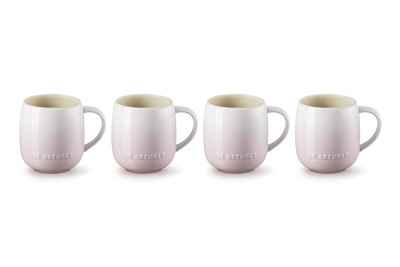 Four light pink mugs with a subtle pattern on a white background