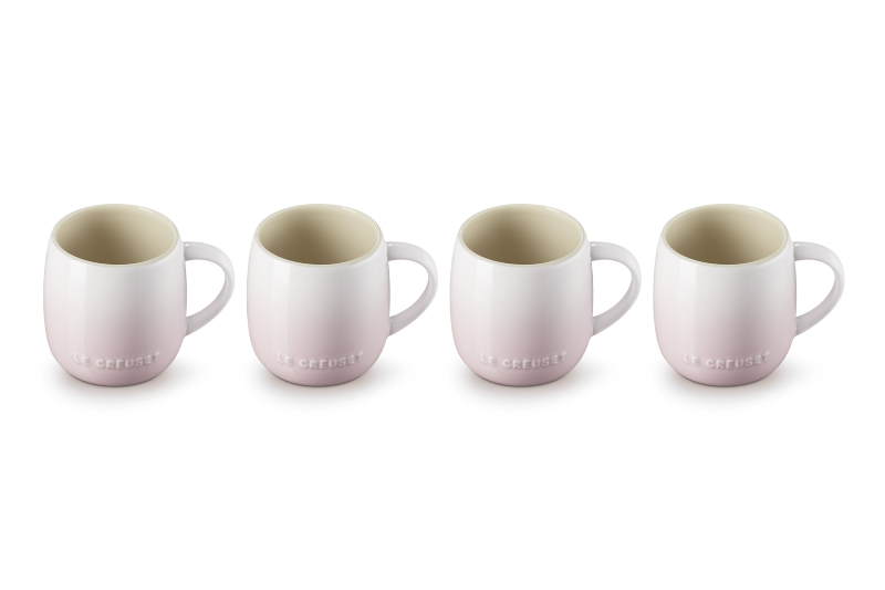 Four ceramic mugs with a subtle pattern on a white background