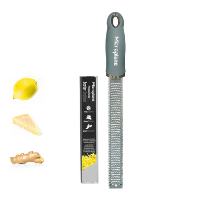 Microplane zester with lemon, ginger, and cheese on a white background