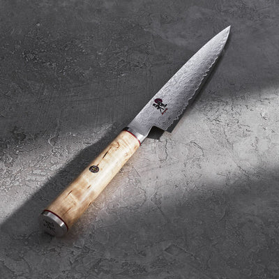 Chef's knife with wooden handle on a textured gray surface