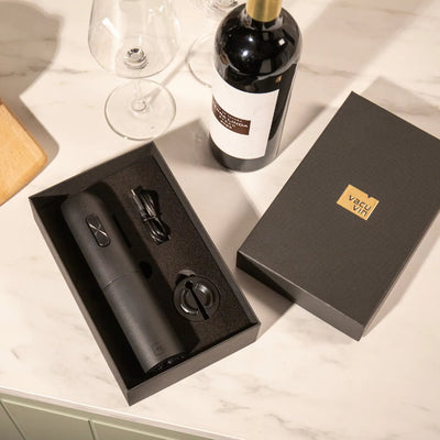 Wine bottle, corkscrew set, and branded box on a marble surface