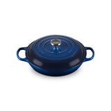 Green cast iron cookware with a lid on a white background